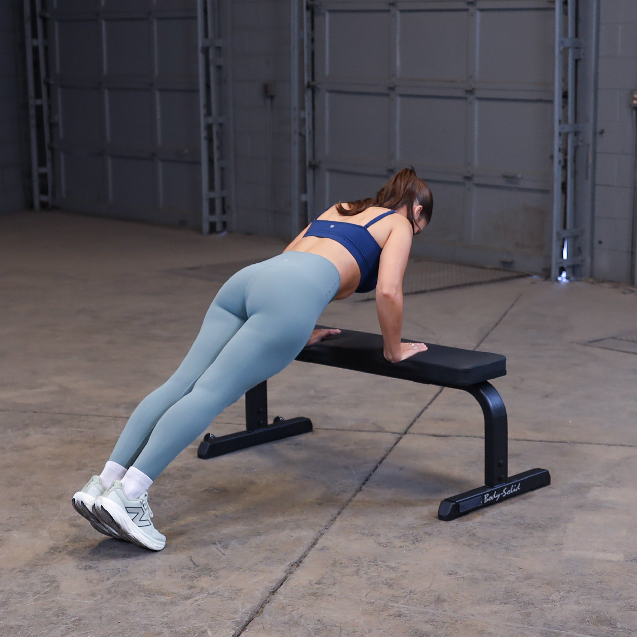 Person performing decline push-ups using the Body-Solid GFB350B flat bench