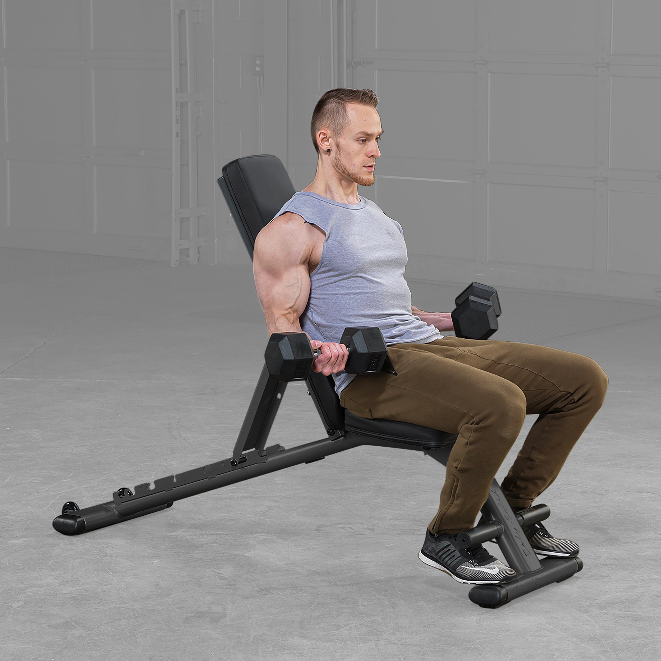 Person performing seated dumbbell curls on Body Solid GFID225B folding adjustable weight bench in a home gym