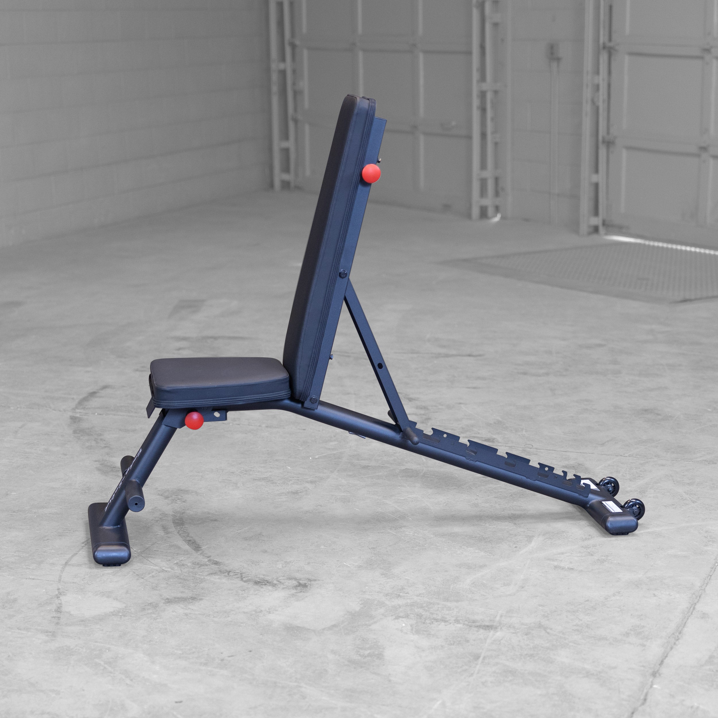 Body Solid GFID225B folding adjustable weight bench shown in vertical position for home gym strength training