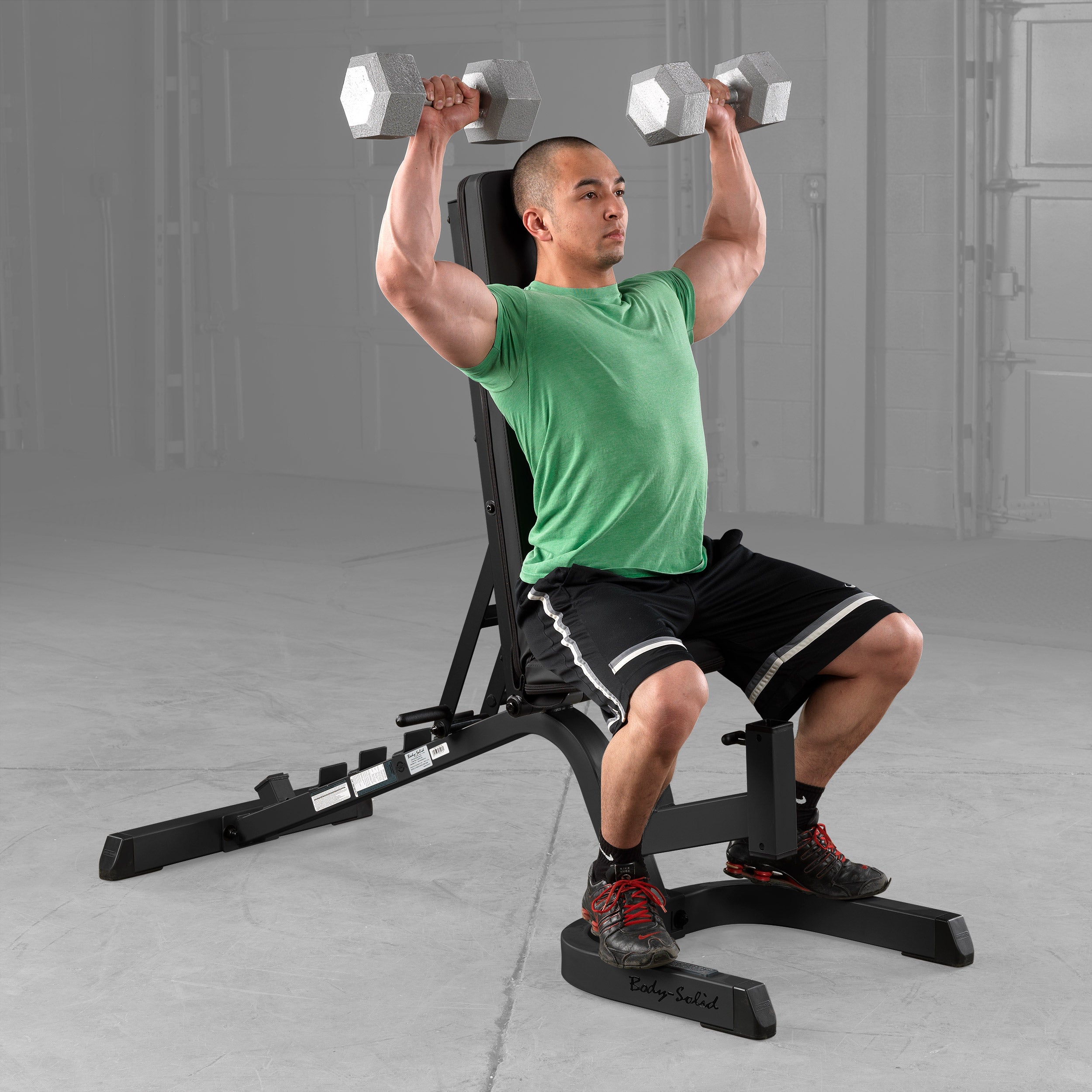 Body-Solid GFID71B Heavy Duty Flat Incline Decline Bench configured in the upright position for seated dumbbell shoulder presses, showcasing the adjustable back pad, stable commercial-grade steel frame, and ergonomic design for upper body strength training
