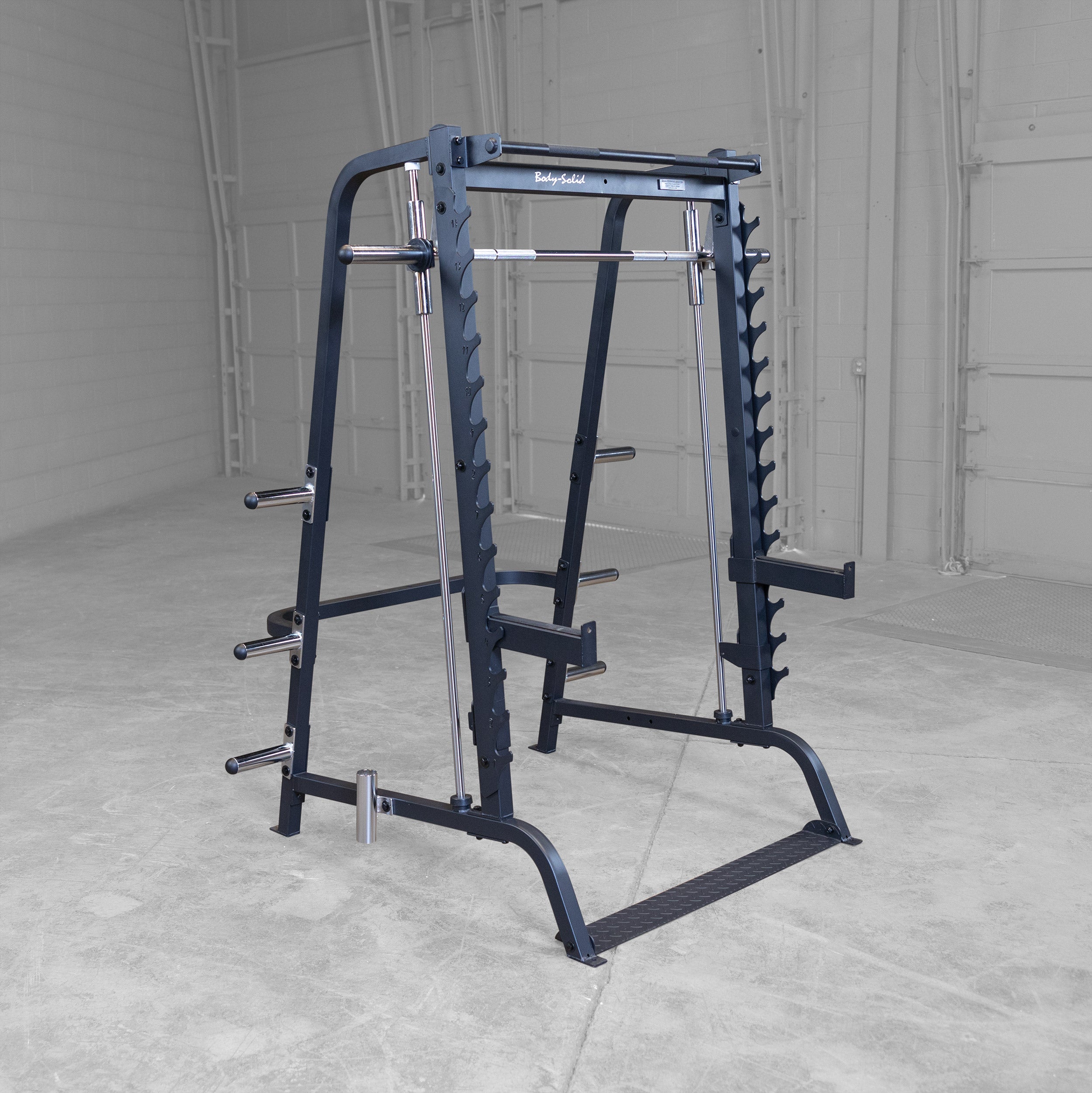 Body-Solid GS348B Series 7 Smith Machine displayed in a gym setting featuring a 7° angled Smith bar, integrated half rack, weight plate storage, and pull-up bar