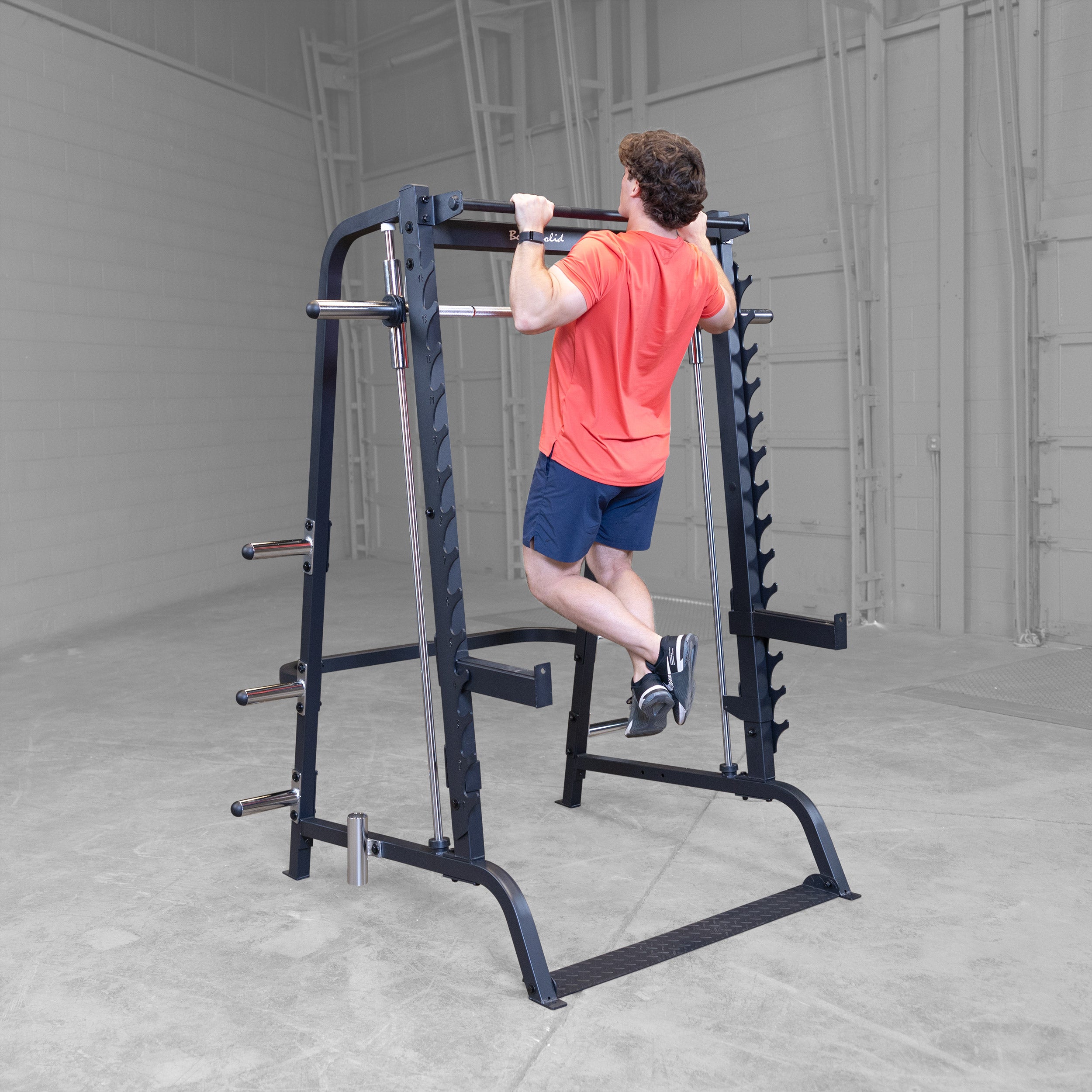 Athlete performing pull ups on the Body-Solid GS348B Series 7 Smith Machine using the integrated pull up bar