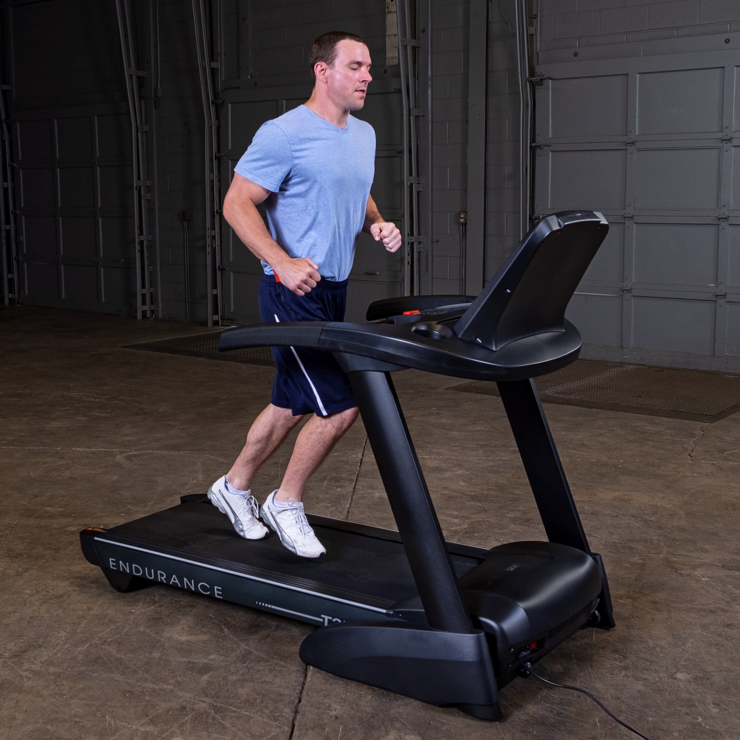 Man walking on Body-Solid Endurance T25 treadmill during home cardio workout