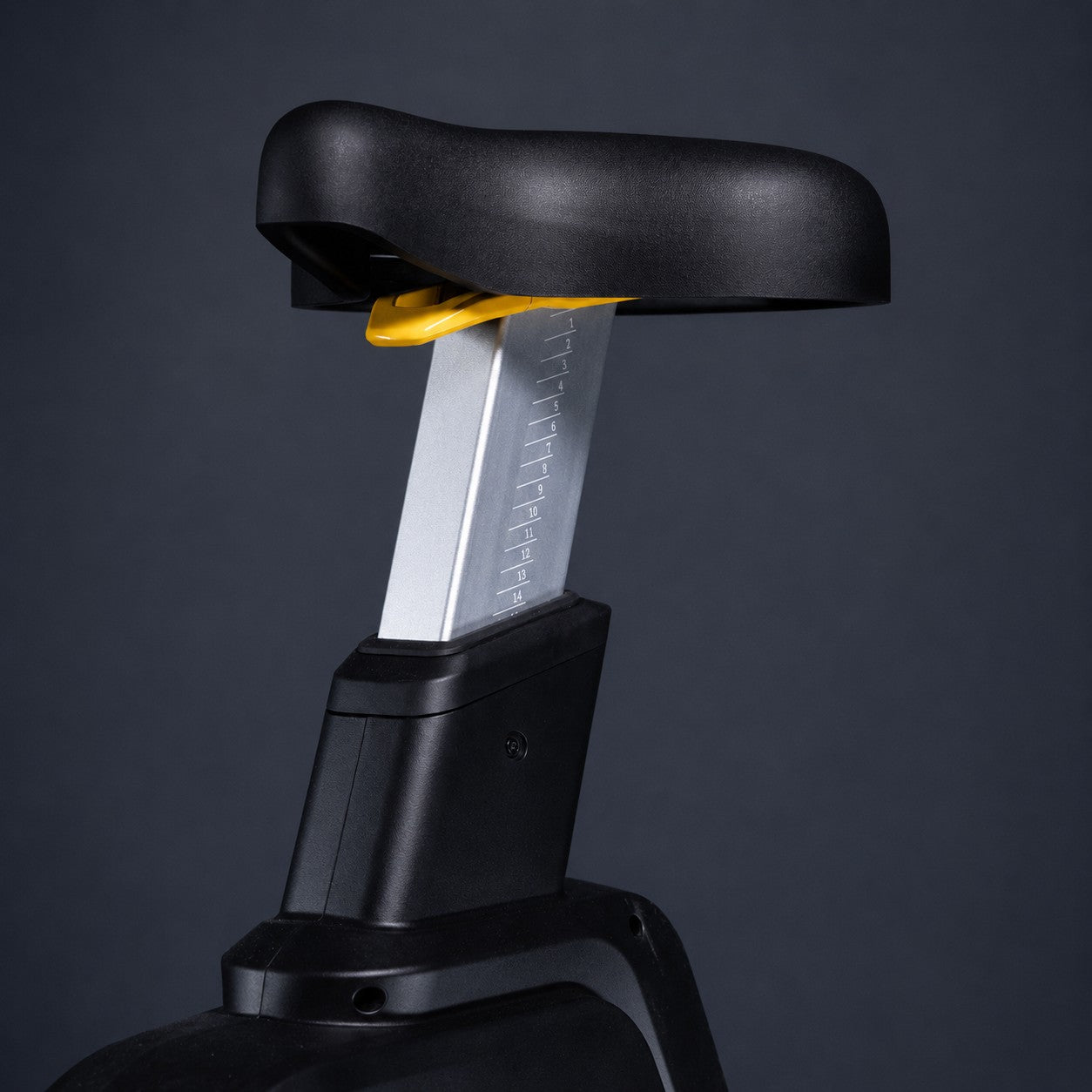 Close-up of the adjustable seat on the ERGOLIFE BU201E upright exercise bike with height adjustment markings and quick-adjust lever