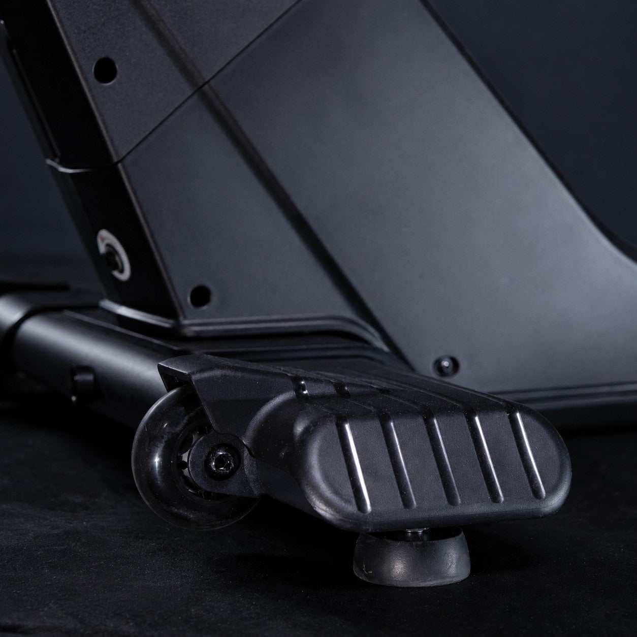 Close-up of the transport wheels and front stabilizer on the ERGOLIFE BU201E upright exercise bike for easy positioning and storage