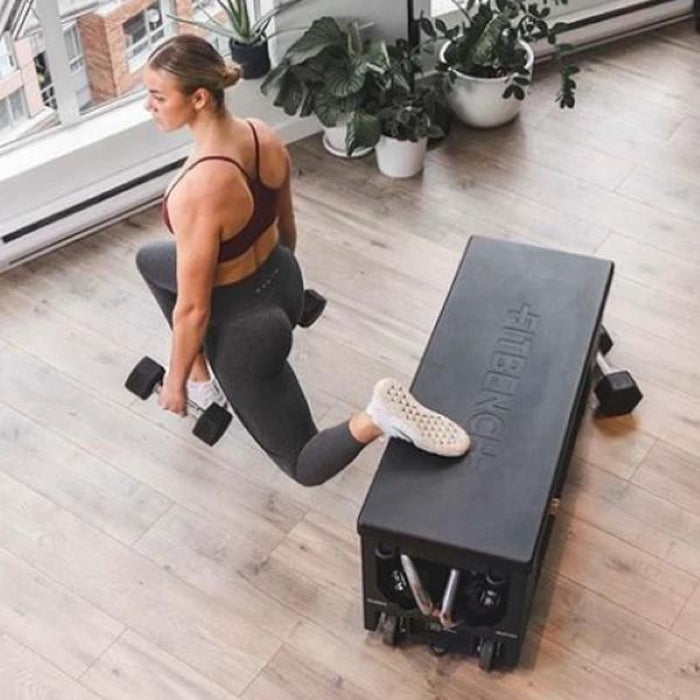 Woman performing Bulgarian split squat with dumbbells using FITBENCH FREE adjustable workout bench