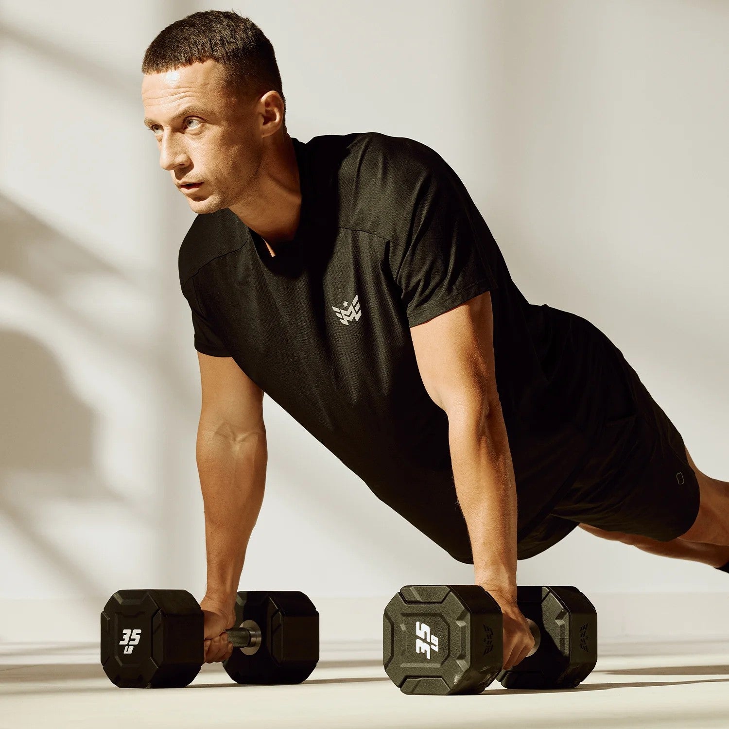 Athlete performing push-ups using Major Fitness urethane octagonal shield dumbbells with anti-roll design and ergonomic knurled handles