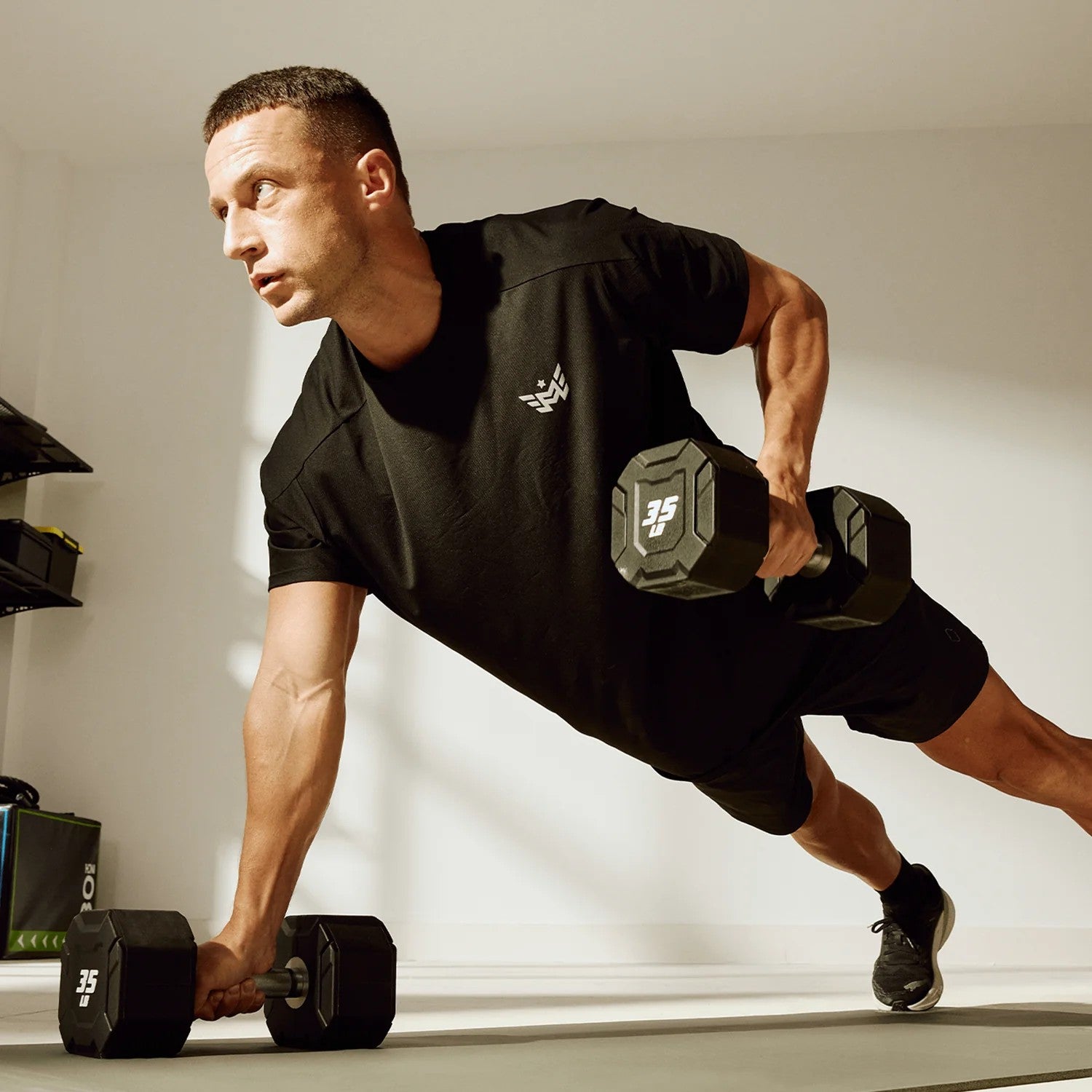 Athlete performing renegade rows using Major Fitness urethane octagonal shield dumbbells with anti-roll heads and ergonomic knurled handles